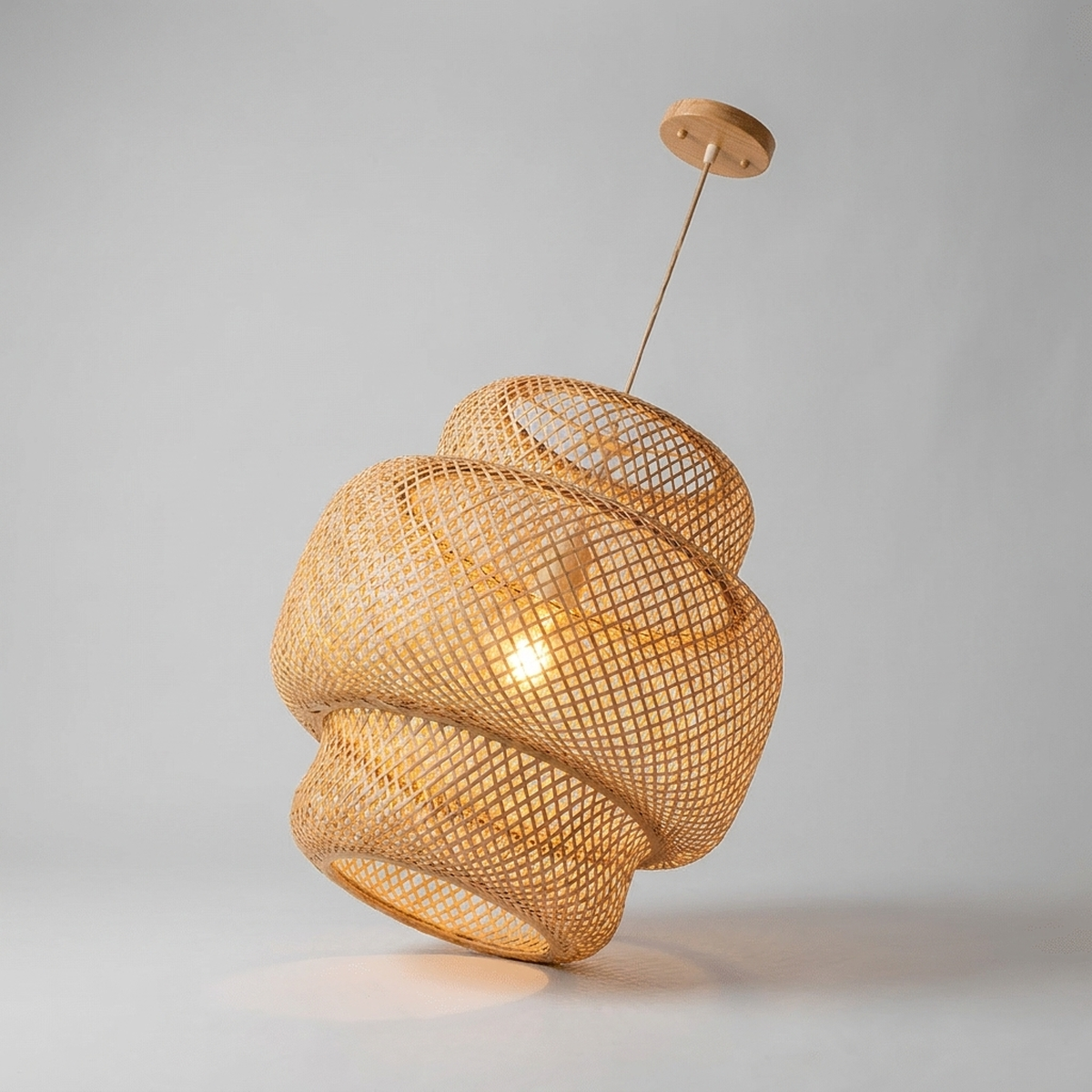 Lustre pendente de bambu rattan aceso - vista em ângulo em fundo neutro